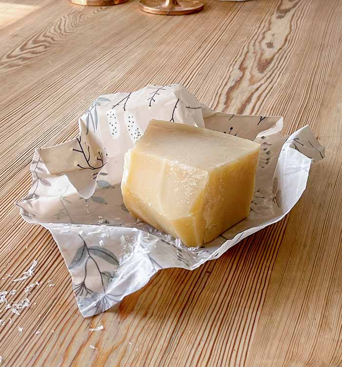 En bit ost som är inpackad i en bivaxduk med Fårö-mönster.